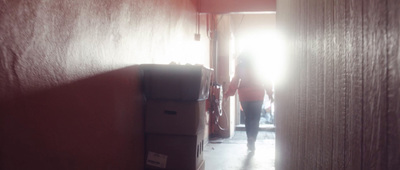 a person standing in a hallway next to a stack of boxes