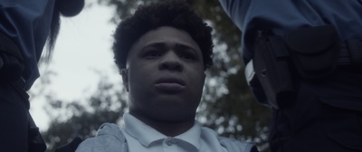 a close up of a person wearing a suit and tie