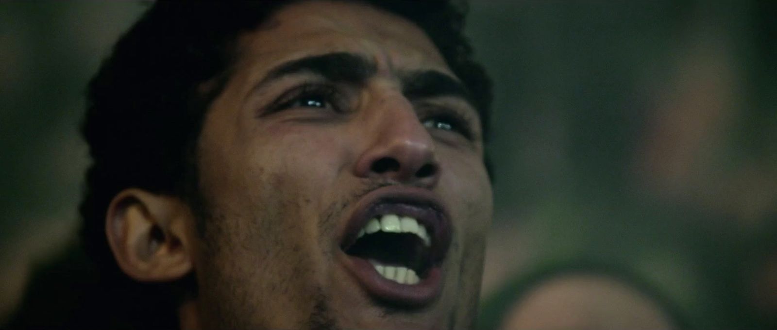 a man with his mouth open in the dark