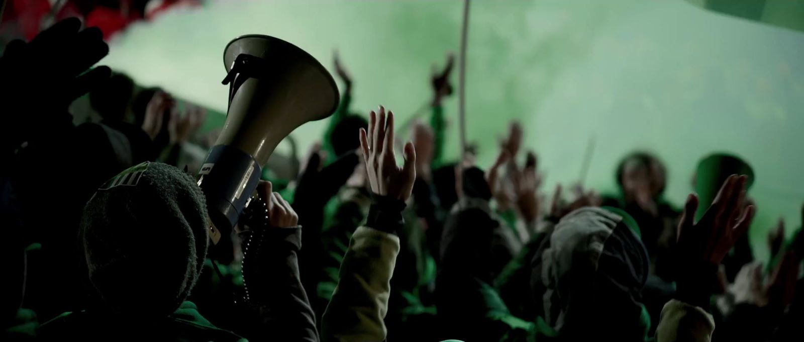 a crowd of people raising their hands in the air