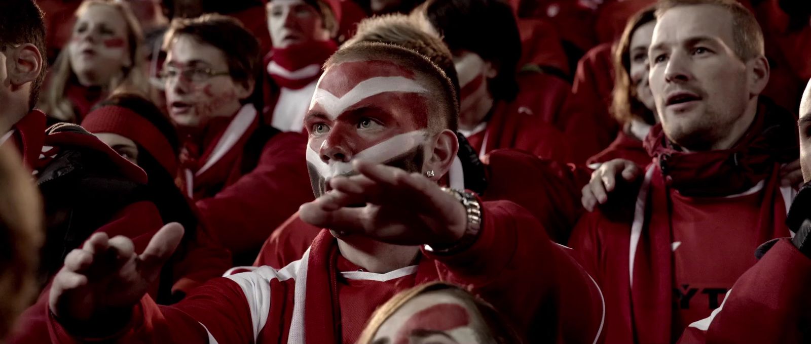 a group of people wearing red and white paint on their faces