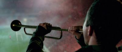 a man playing a trumpet in a dark room