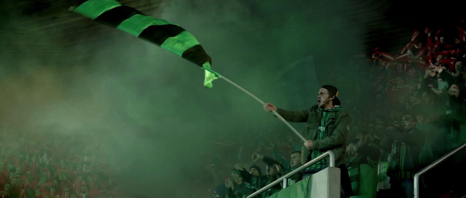 a man holding a green and black striped flag