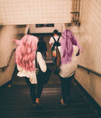 two women with pink and purple hair walking up a flight of stairs