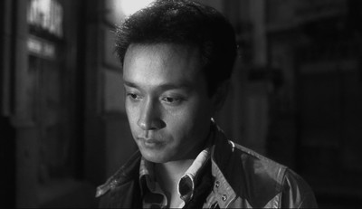 a black and white photo of a man wearing a shirt and tie