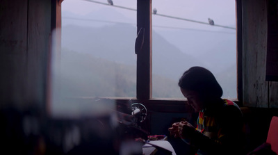 a woman sitting at a table in front of a window