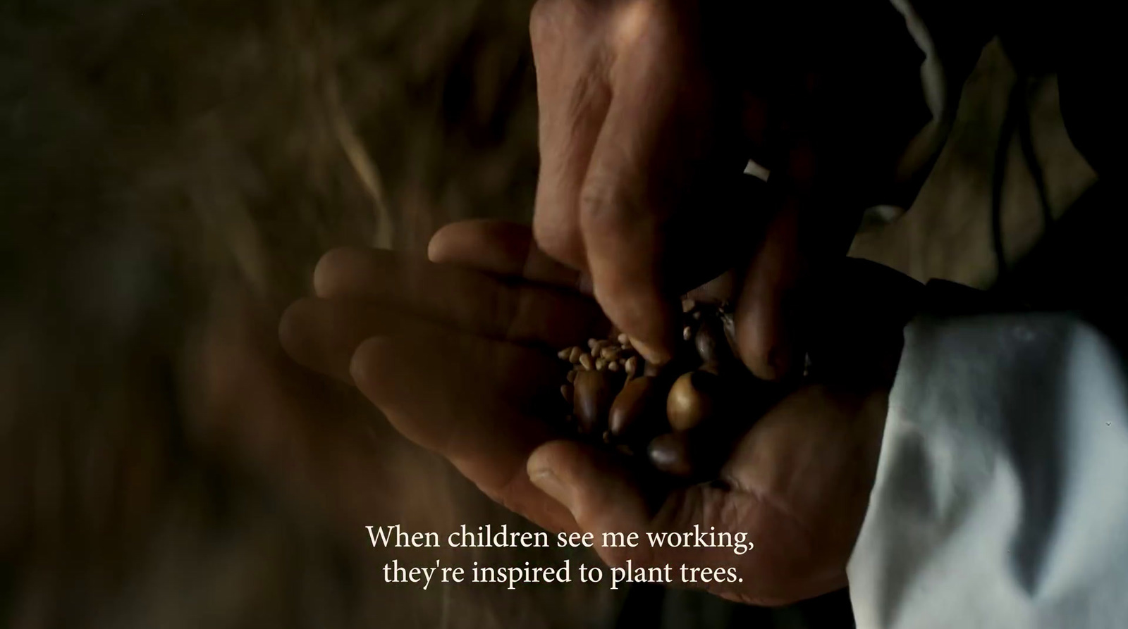 a person holding a handful of nuts in their hands