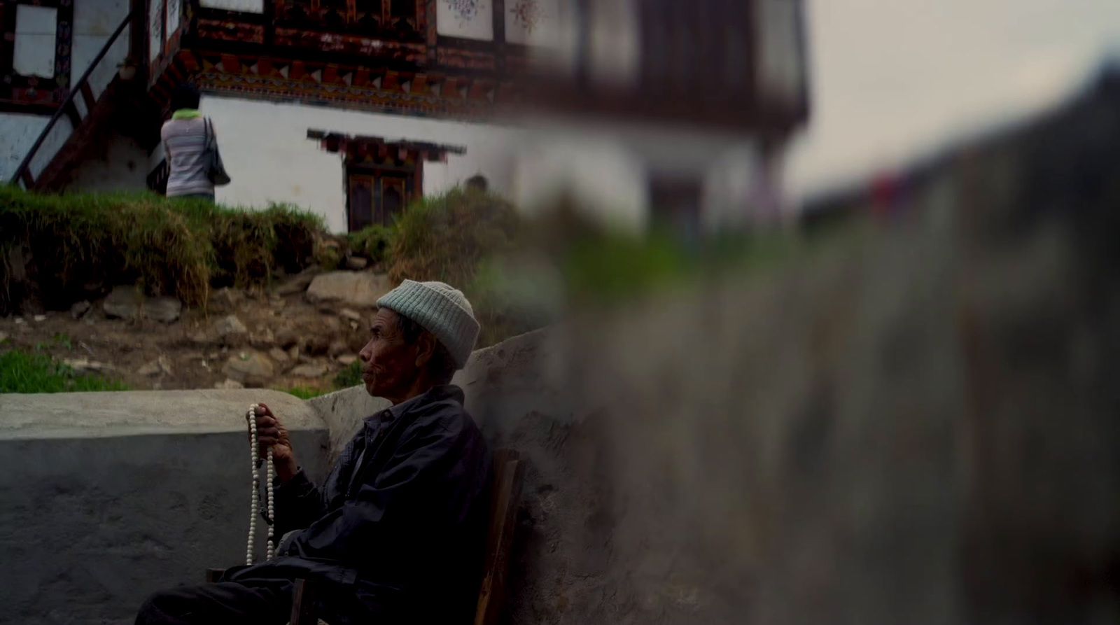 a man sitting on a bench next to a building