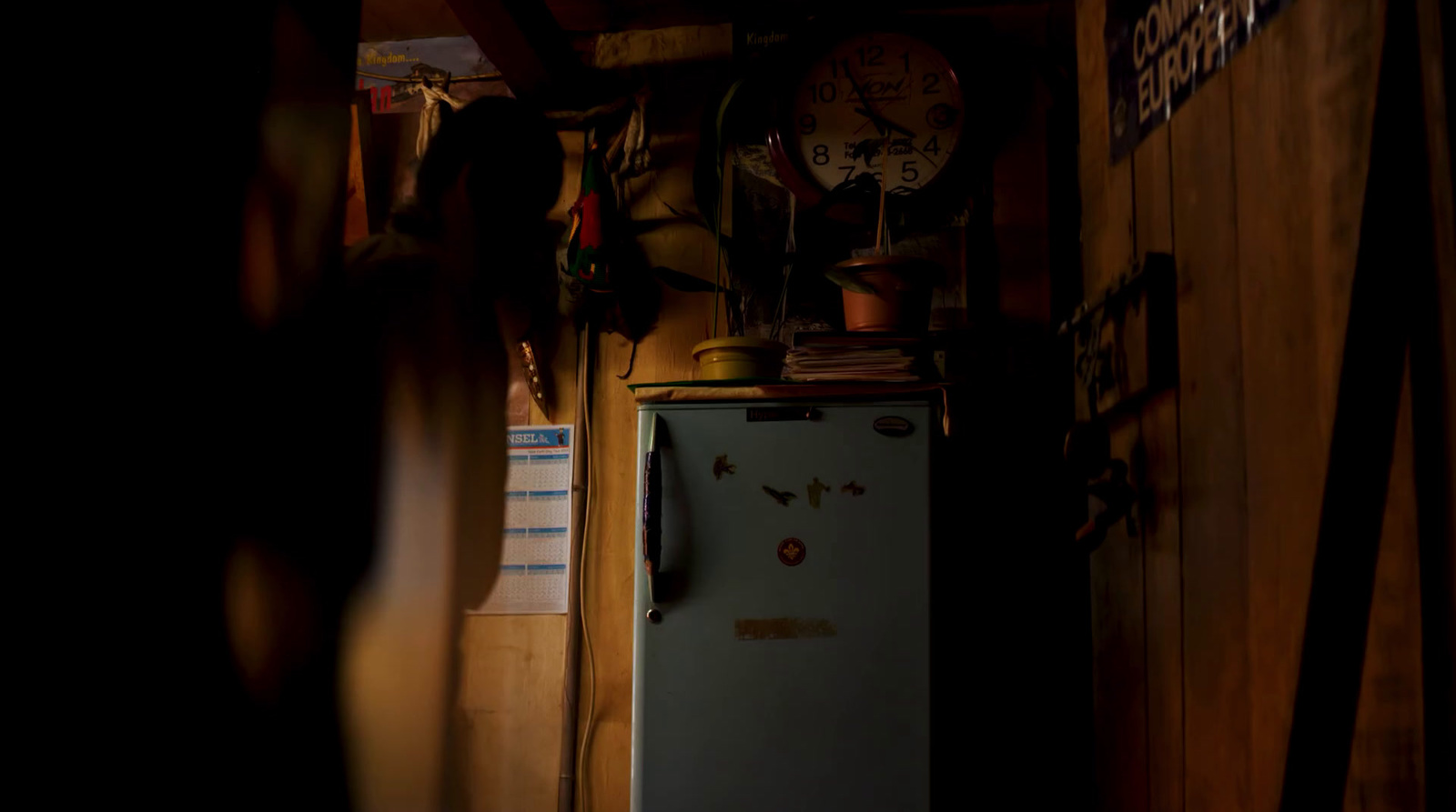 a refrigerator in a room with a clock on the wall