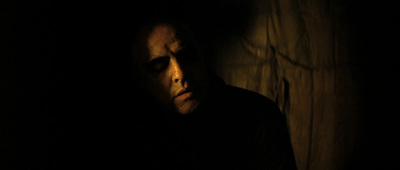 a man in a dark room with his eyes closed