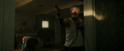 a man holding a gun in a dark room