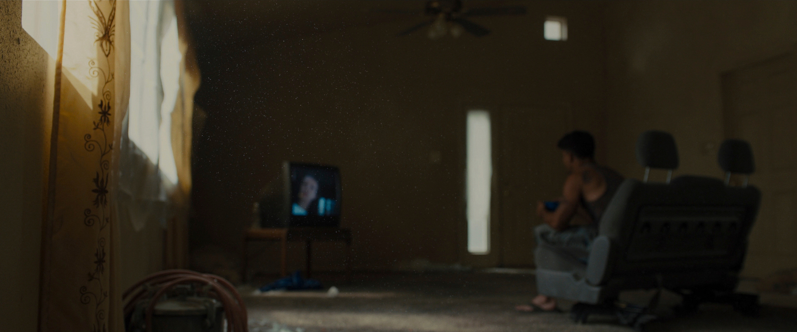 a man sitting in a chair watching tv