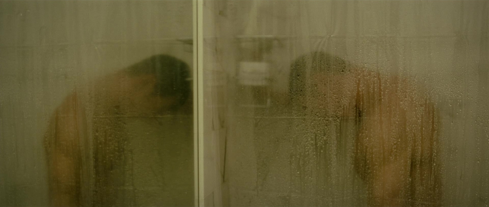 a man standing in front of a shower in a bathroom