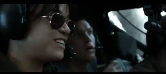 a couple of people sitting in a plane with headphones