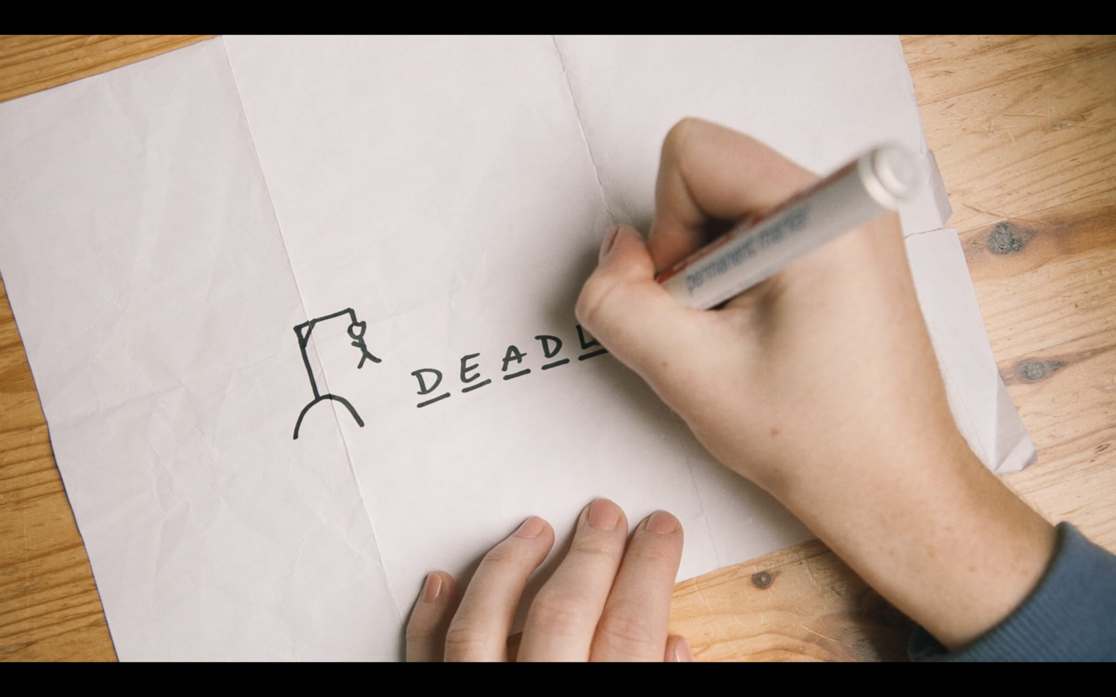 a person writing on a piece of paper with a pen