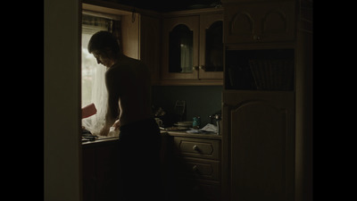 a man standing in a kitchen next to a window