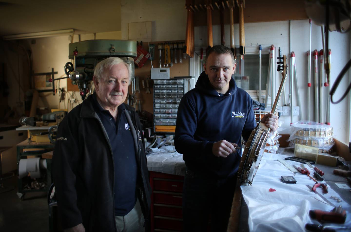 two men standing next to each other in a room