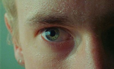 a close up of a man's face with a blue eye