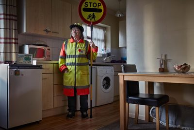 a woman in a yellow jacket holding a stop sign