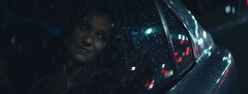 a woman looking out the window of a car at night