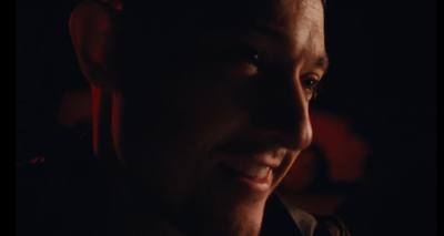 a close up of a man smiling in the dark