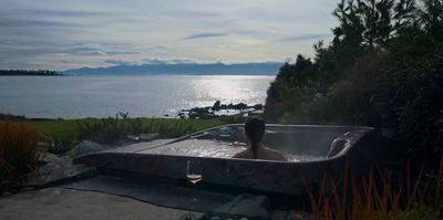 a woman sitting in a hot tub with a glass of wine