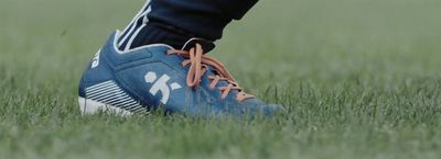 a close up of a person's shoes in the grass