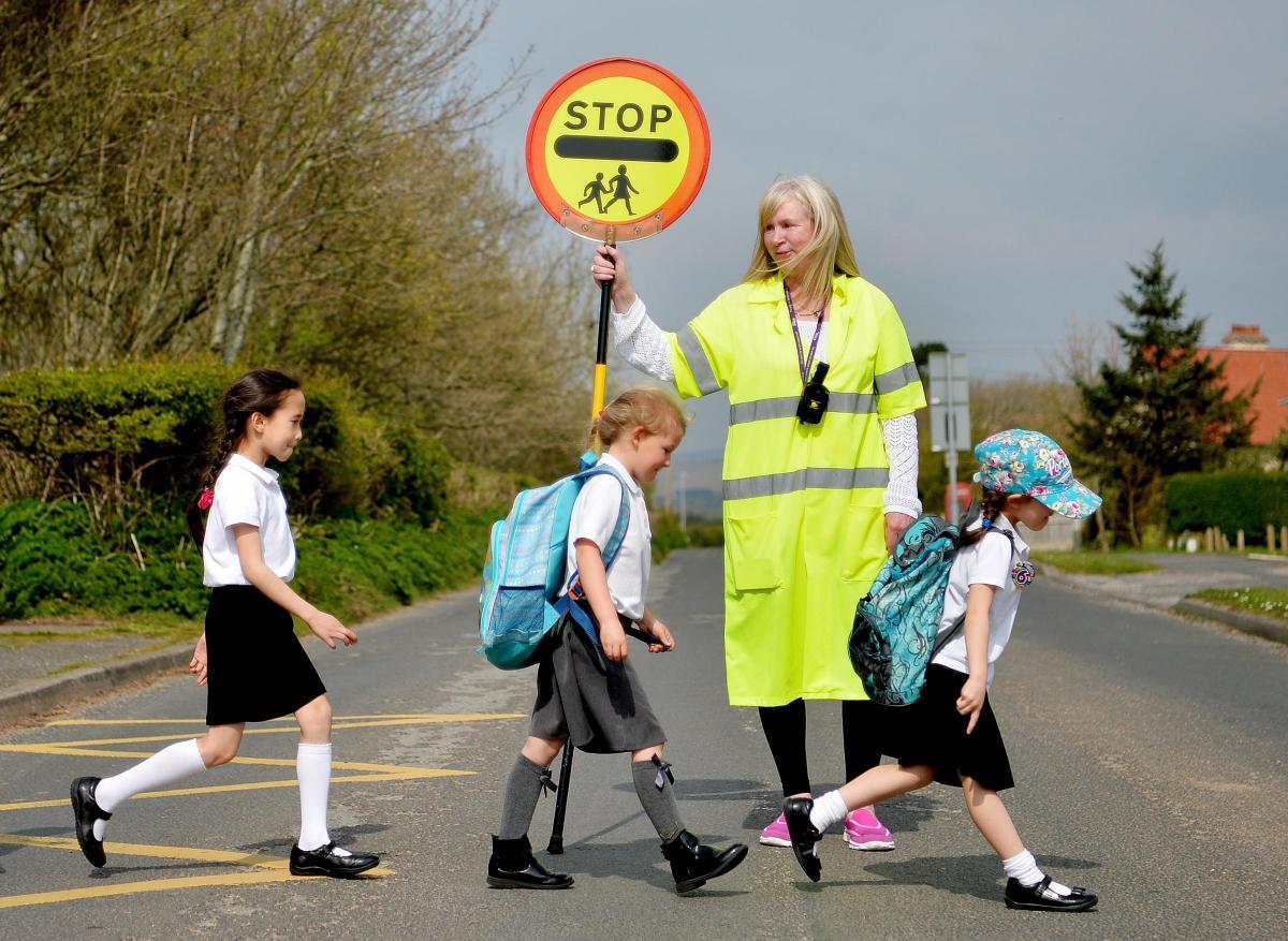 a woman holding a stop sign in the middle of a road