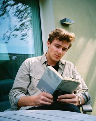 a man sitting on a bench reading a book