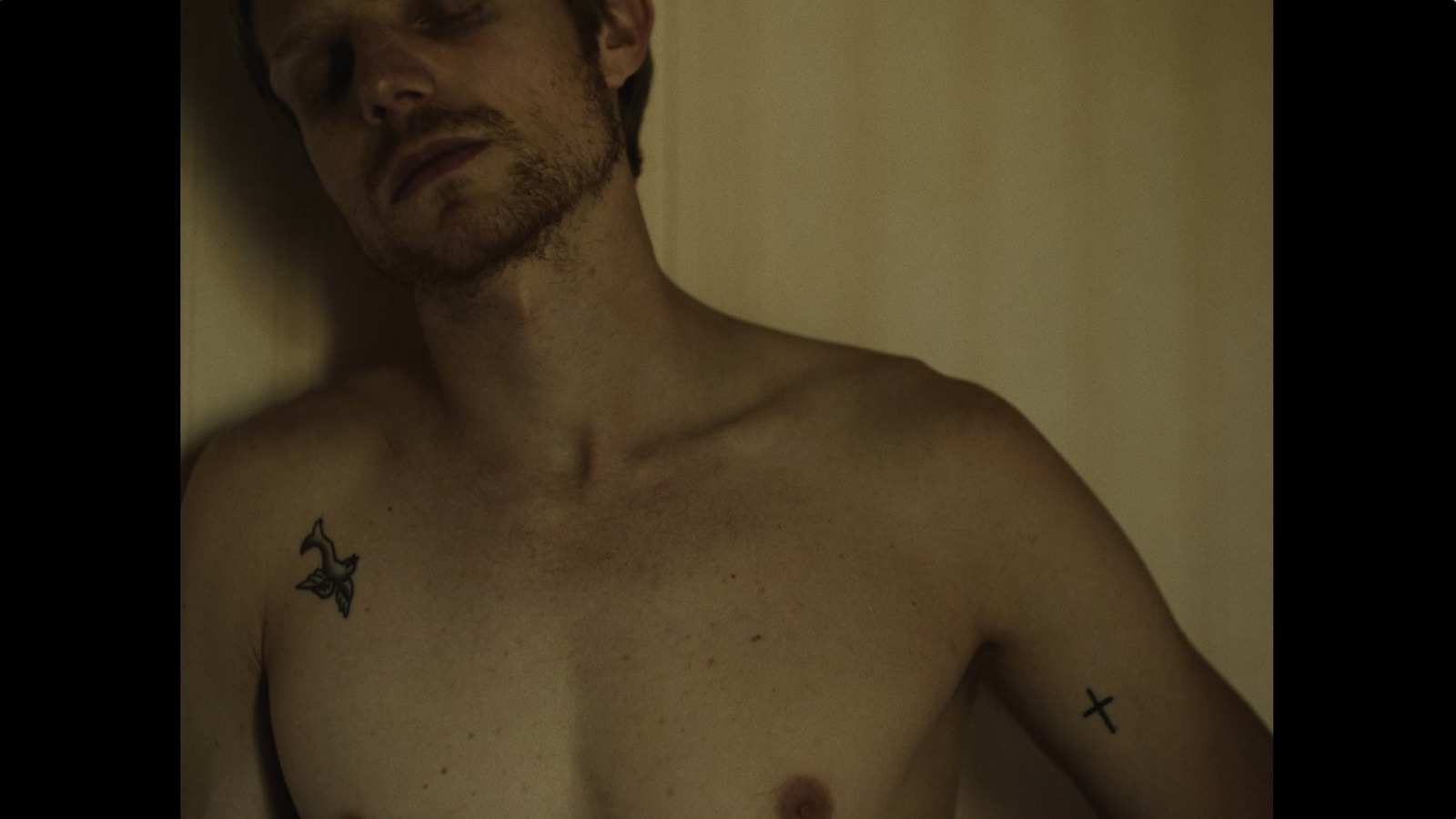 a man with a cross tattoo on his chest