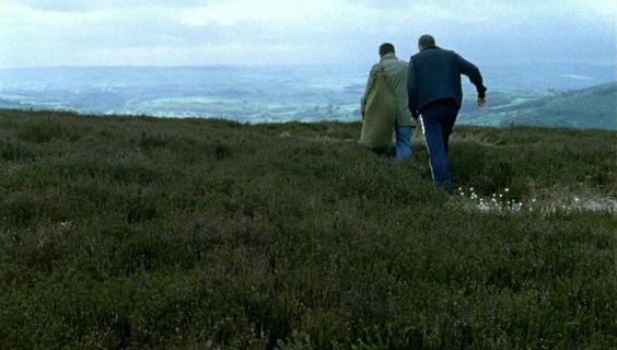 a man and a woman walking up a hill