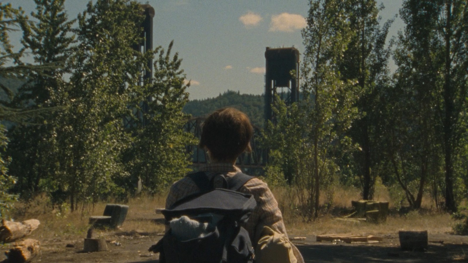 a person sitting on a bench in the woods