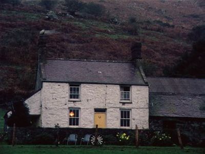 a white house sitting on top of a lush green hillside