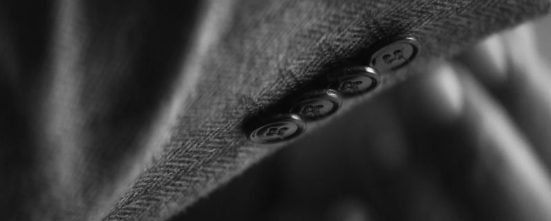 a black and white photo of buttons on a jacket