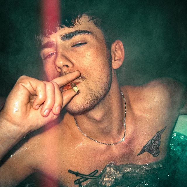 a man smoking a cigarette in a bathtub