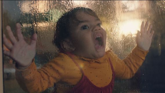 a little girl standing in front of a window