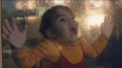 a little girl standing in front of a window