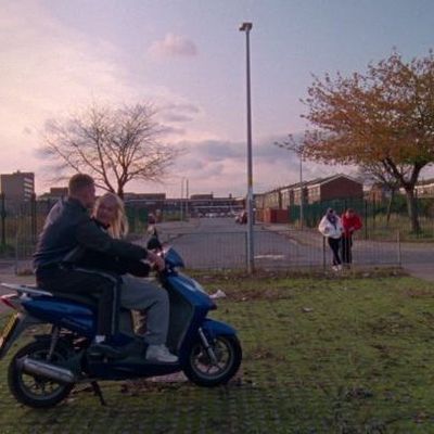 a man and a woman are riding a scooter