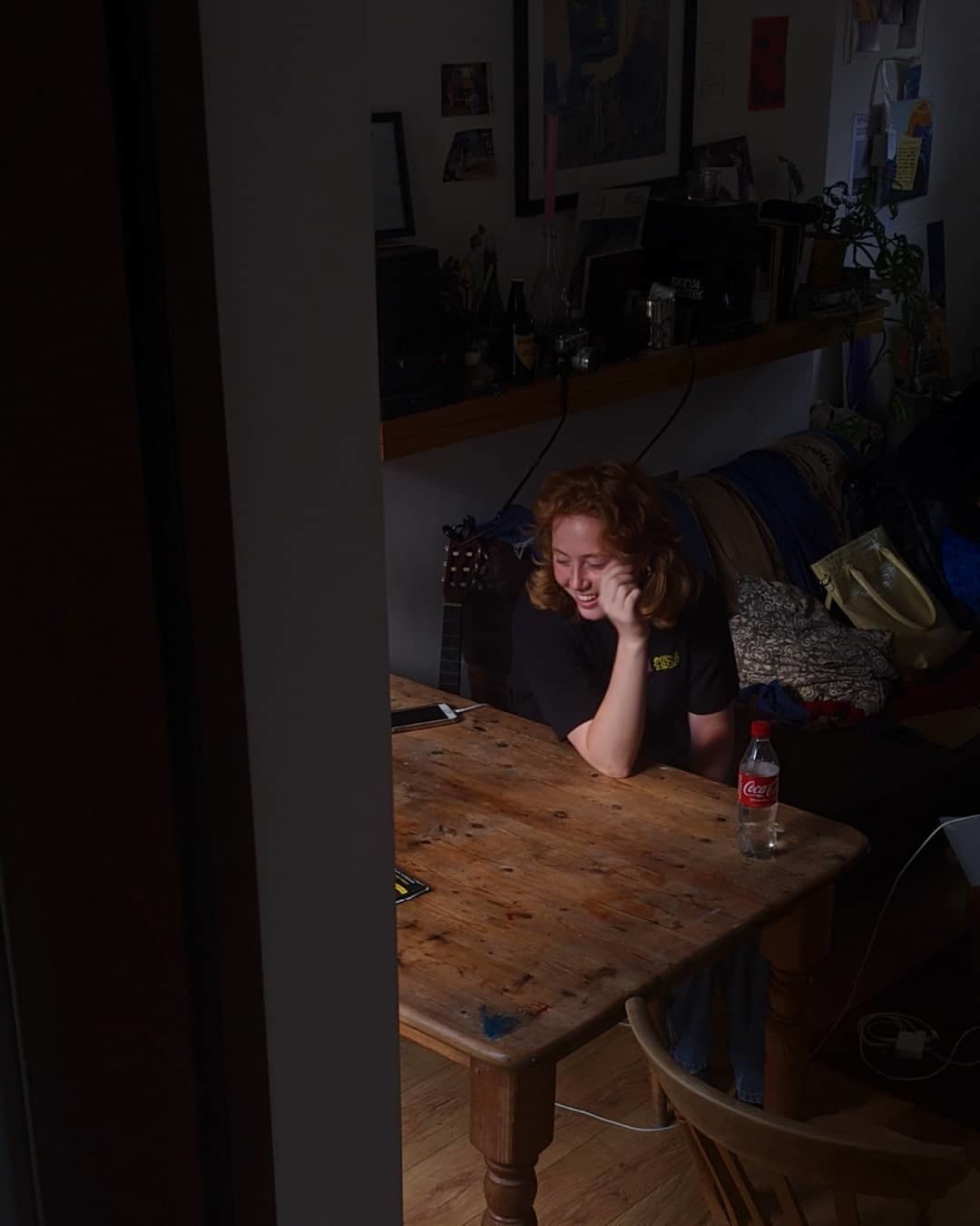 a woman sitting at a table talking on a cell phone