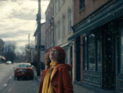 a woman standing on a street corner in the snow