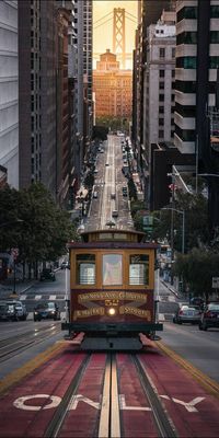 a trolley car traveling down a street next to tall buildings