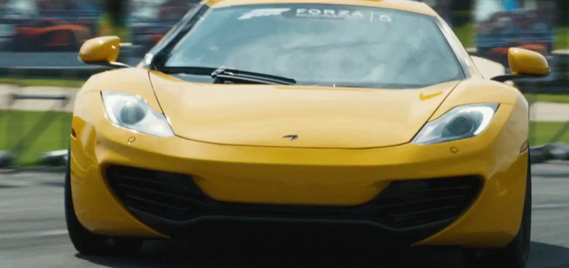 a yellow sports car driving down a race track