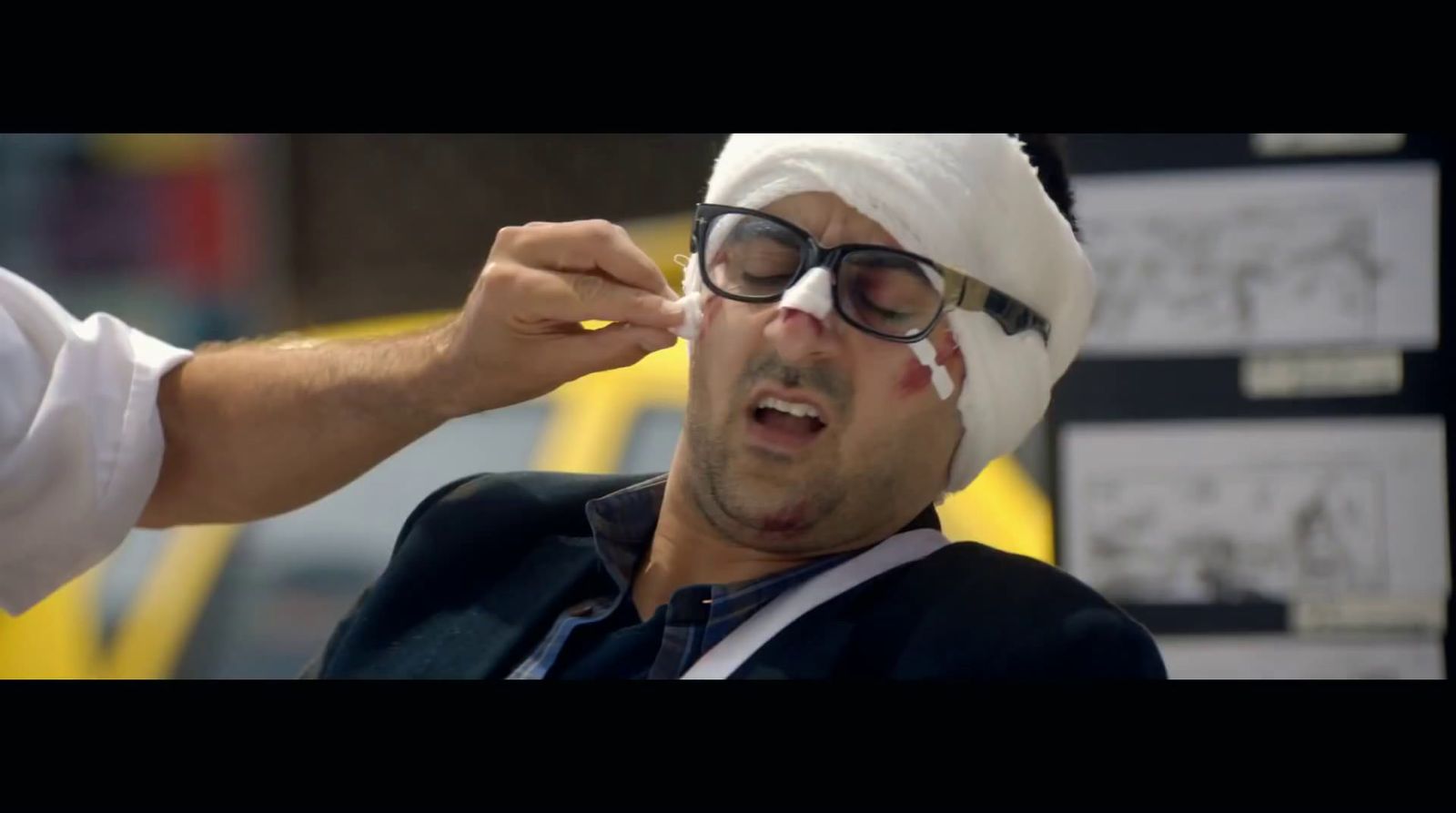 a man with a bandage on his head is putting something on his face