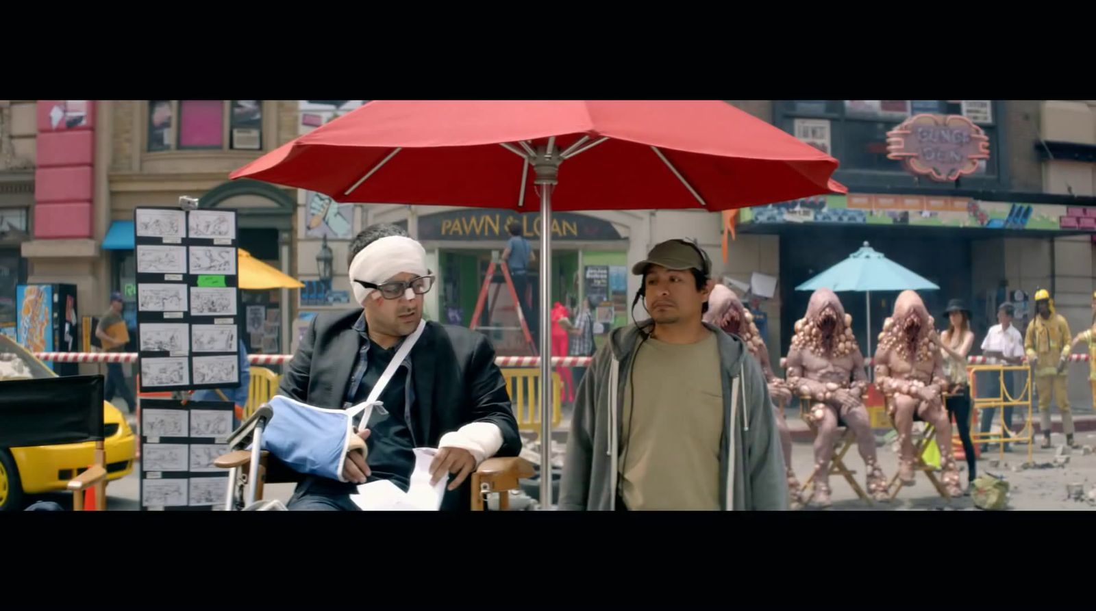 a couple of men standing under a red umbrella