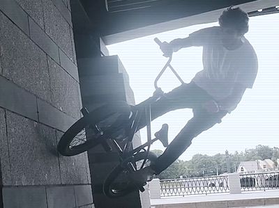 a man riding a bike up the side of a building