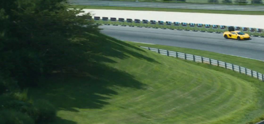 a yellow sports car driving down a winding road