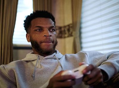 a man sitting in a chair holding a remote control