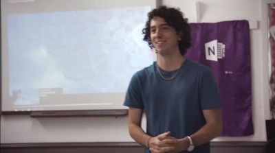 a man standing in front of a projector screen