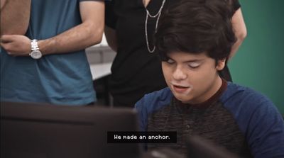 a young man sitting in front of a computer monitor