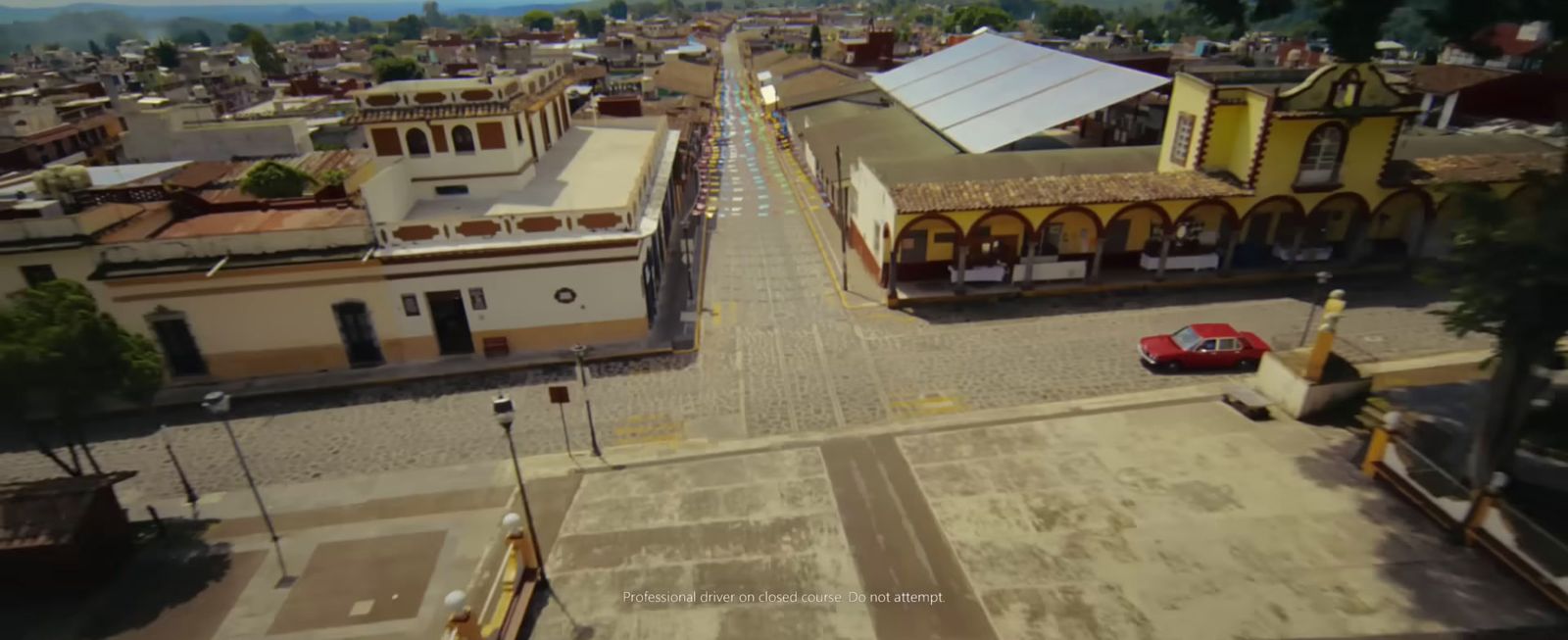 an aerial view of a small town with a red car